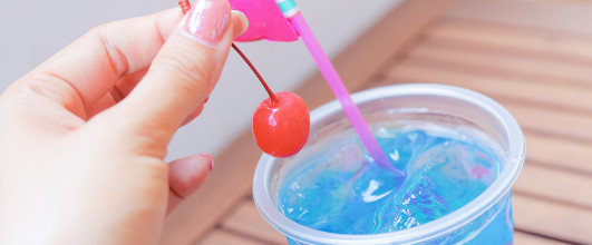 素材サイト「GIRLY DROP」より、飲み物についていたサクランボをつまむ指先。 アイキャッチ画像。