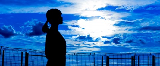 素材サイト「写真AC」より、青い雲と女性のシルエット。Shadiaさんの作品。 アイキャッチ画像。